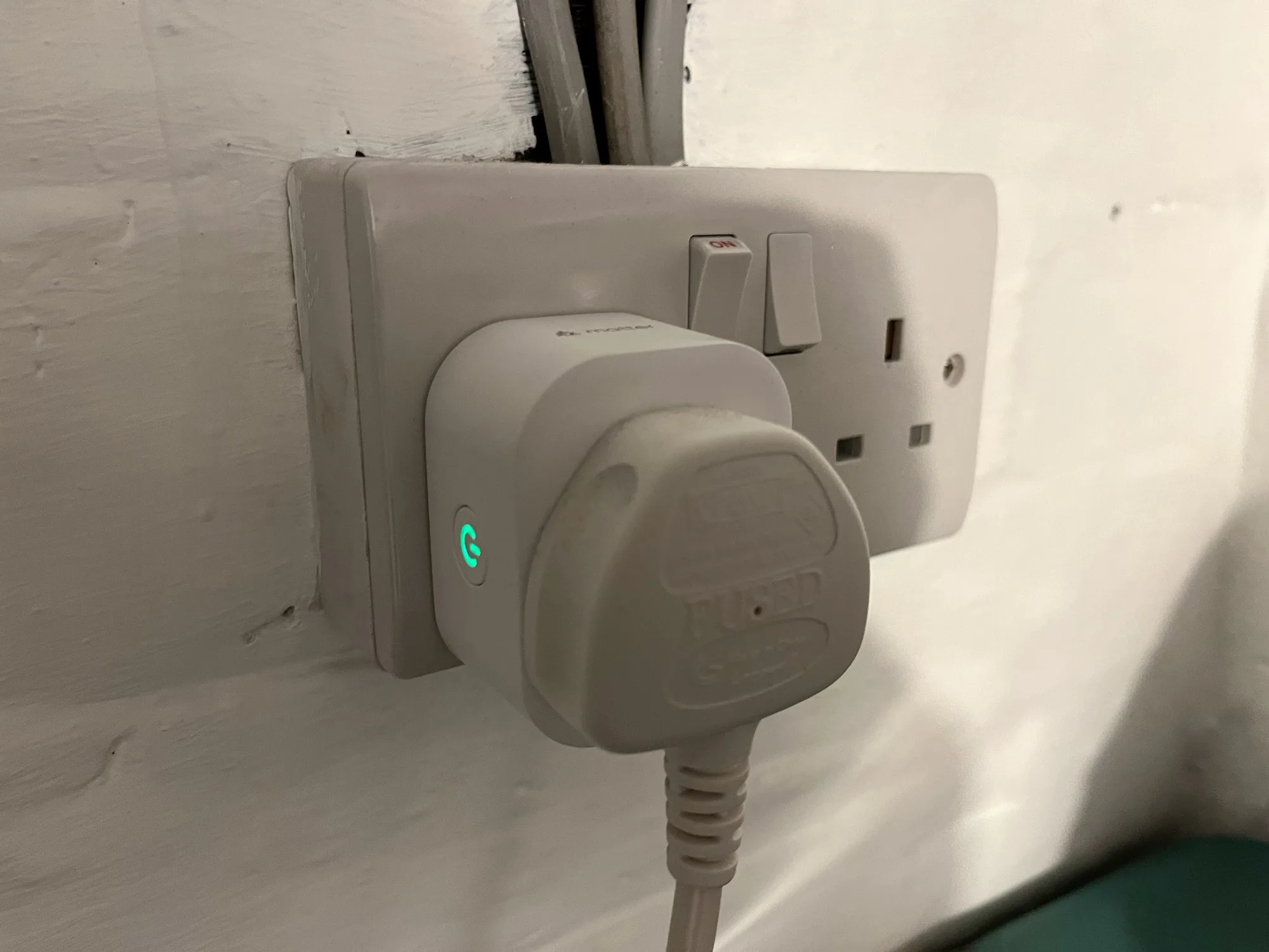 A photo of a Meross energy monitoring smart plug in a UK plug socket