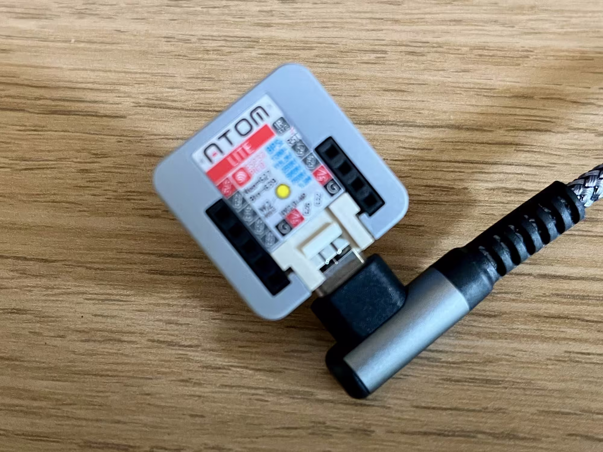 A photo of an m5stack Atom Lite which has been flashed with ESPHome firmware to act as a Bluetooth Proxy for Home Assistant