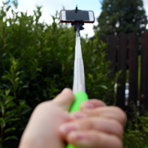 A photo of an iPhone on the end of a Camkix Selfie Stick