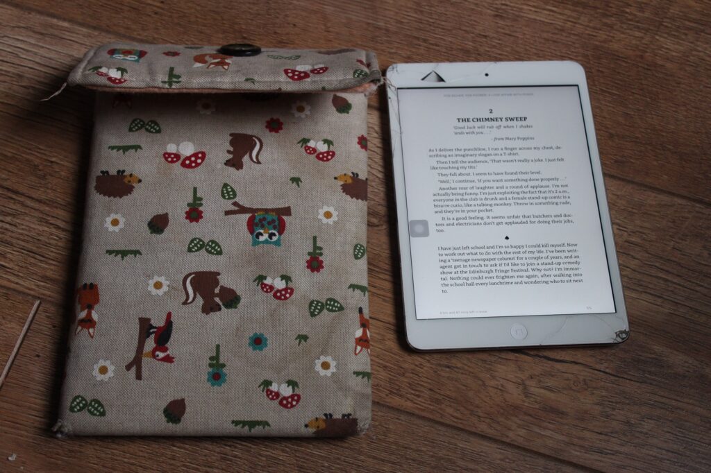 An iPad Mini 2 next to a case with a wildlife pattern on it