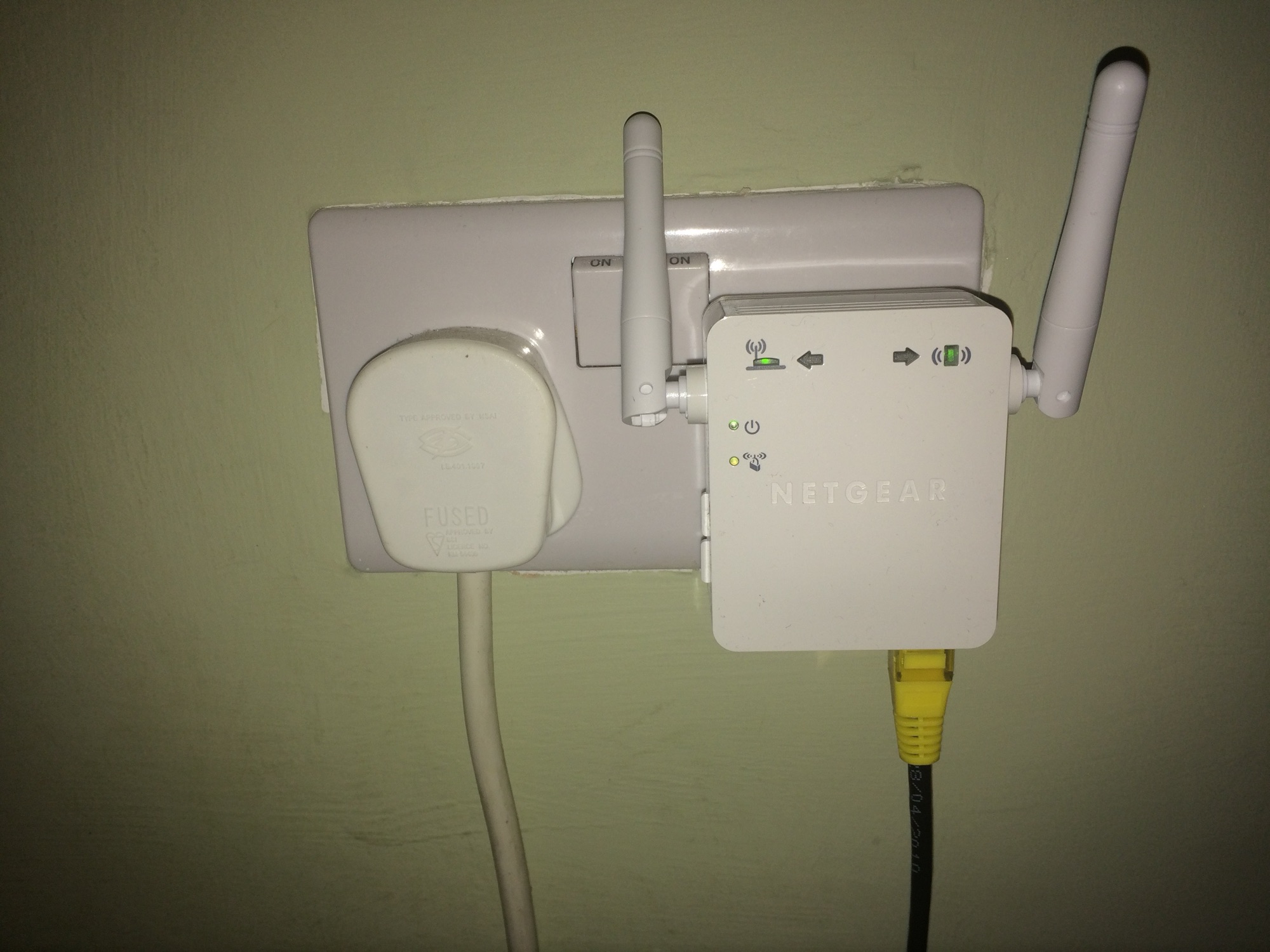 A photo of the Netgear WN3000RP Wifi Range Extender plugged into a wall socket