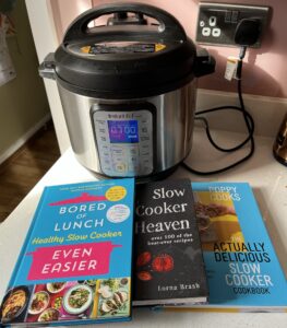 A photo of our Instant Pot, which we use as a slow cooker. In front of it are several slow cooker cookbooks