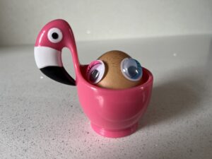 An egg with googly eyes in a flamingo-shaped egg cup. This is supposed to somehow represent 'Easter holidays'.