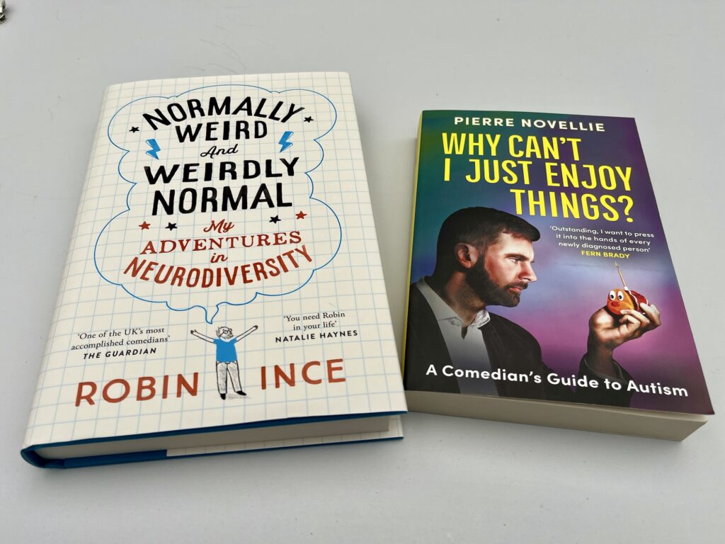 A photo of two books, 'Normally Weird and Weirdly Normal' by Robin Ince and 'Why Can't I Just Enjoy Things'