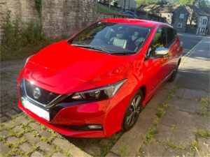 A photo of a red Nissan Leaf