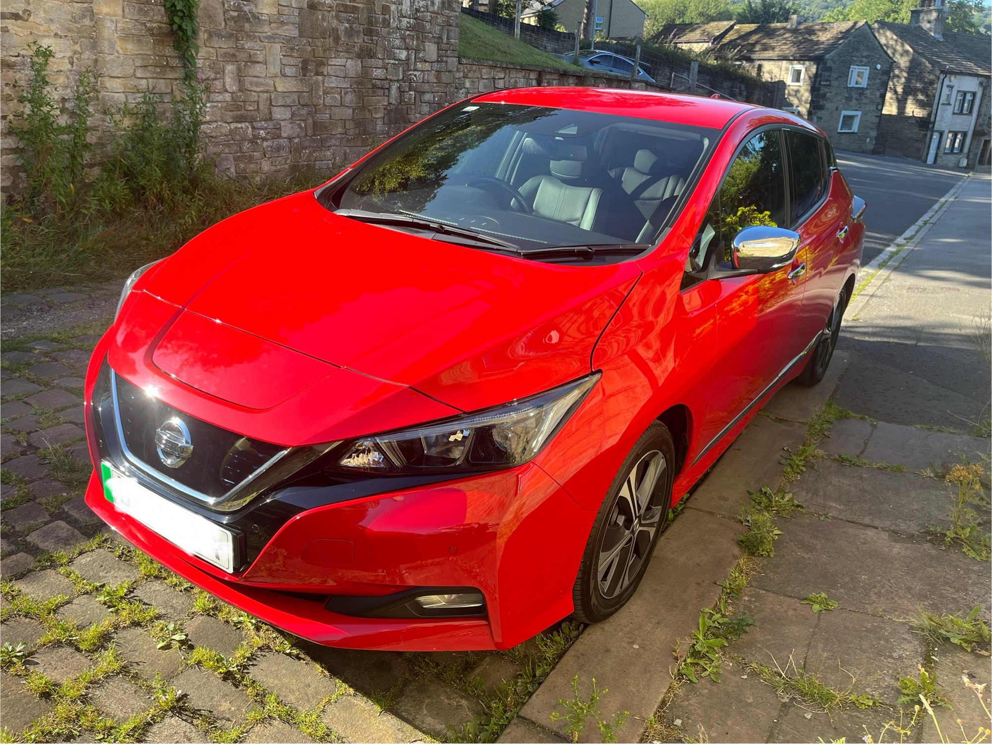 A photo of a red Nissan Leaf
