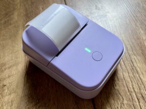 A photo of the Etikez PM260 Bluetooth label printer, in a pastel purple colour.